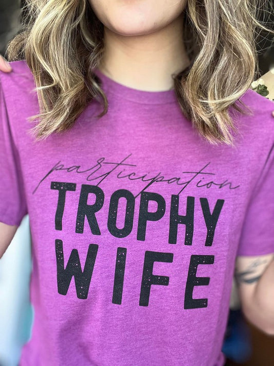 Let your wife know she's a trophy with this stylish Trophy Wife Tee. Featuring fun and cheeky messaging, she'll love the look and sentiment. Even when she's in her messy hair, sweatpants, and munching on take out food, she's still a winner in your eyes!